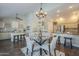 Well-lit dining area showcases a glass table with seating for four, complemented by stylish overhead lighting and hardwood floors at 11085 E Becker E Ln, Scottsdale, AZ 85259