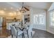 Bright dining area featuring a glass table set for four, modern chandelier, and a view into the kitchen and living room at 11085 E Becker E Ln, Scottsdale, AZ 85259