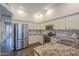 Bright kitchen featuring stainless steel refrigerator, granite counters, wooden floors and white cabinets at 11085 E Becker E Ln, Scottsdale, AZ 85259