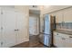 Stainless steel refrigerator beside white double doors and upper cabinets at 11085 E Becker E Ln, Scottsdale, AZ 85259