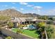 Enjoy an aerial view of this estate with a putting green, pool, and lush landscaping at 13141 E Cibola Rd, Scottsdale, AZ 85259