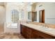 Bathroom with a soaking tub, double sink vanity, and decorative glass block windows that offer plenty of natural light at 13141 E Cibola Rd, Scottsdale, AZ 85259