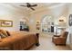 Bedroom with a ceiling fan, vaulted ceiling, neutral walls, niche shelving and a large shuttered window at 13141 E Cibola Rd, Scottsdale, AZ 85259