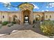 Inviting home featuring a stone archway entrance with a tiled path through desert landscaping at 13141 E Cibola Rd, Scottsdale, AZ 85259