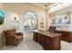 Office features a large arched window with custom shutters and decorative niche shelving with a built-in desk at 13141 E Cibola Rd, Scottsdale, AZ 85259