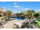 Resort-style pool features a rock waterfall, palm trees, and a nearby putting green for recreation at 13141 E Cibola Rd, Scottsdale, AZ 85259