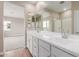 Bright bathroom features a double sink vanity with white cabinets and a large mirror at 4924 W Beryl Ave, Glendale, AZ 85302