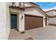 Home featuring a terracotta roof, stucco siding, a blue front door, and a spacious three-car garage at 4924 W Beryl Ave, Glendale, AZ 85302