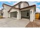 Attached three-car garage with automatic doors, exterior lighting, and a concrete driveway offer convenient parking at 4924 W Beryl Ave, Glendale, AZ 85302