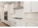 Close up of the kitchen showcasing stainless steel hood, cooktop, herringbone backsplash and white cabinetry at 4924 W Beryl Ave, Glendale, AZ 85302