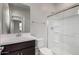 Bright bathroom featuring a modern vanity, toilet, and glass-enclosed shower with white tile surround at 4925 W Beryl Ave, Glendale, AZ 85302
