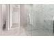 Modern glass shower in updated bathroom with marble floors and accents at 4925 W Beryl Ave, Glendale, AZ 85302