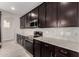 Updated kitchen boasts dark wood cabinetry, stylish backsplash, and stainless steel appliances at 4925 W Beryl Ave, Glendale, AZ 85302