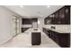 Modern kitchen features a center island, dark wood cabinets, and stainless steel appliances at 4925 W Beryl Ave, Glendale, AZ 85302