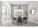 Bright dining room with a round table, six chairs, and large windows at 18849 E Azalea Dr, Queen Creek, AZ 85142