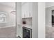 Built-in kitchen bar with beverage fridge and white cabinetry at 18849 E Azalea Dr, Queen Creek, AZ 85142