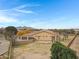 Aerial view of the house, showcasing its back elevation, large yard, and distant mountains at 24002 S 201St Ct, Queen Creek, AZ 85142