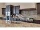 Modern kitchen with granite countertops, stainless steel appliances, and dark wood cabinets at 24002 S 201St Ct, Queen Creek, AZ 85142