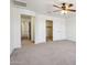 This bedroom features neutral carpet, white walls, ceiling fan and a view into the hall at 2542 N Riley Rd, Buckeye, AZ 85396
