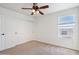 Bedroom with neutral carpet, ceiling fan, a closet with sliding doors and a view to the exterior at 2542 N Riley Rd, Buckeye, AZ 85396