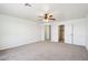 Bedroom featuring neutral carpet, white walls, a ceiling fan and an adjacent closet at 2542 N Riley Rd, Buckeye, AZ 85396