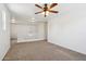 Bonus room features neutral carpet, white walls, a ceiling fan and stairs to the main level at 2542 N Riley Rd, Buckeye, AZ 85396