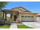Inviting two-story home with a covered front porch, well-manicured lawn, and a two-car garage at 2542 N Riley Rd, Buckeye, AZ 85396