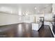 Bright open kitchen features white cabinets, stainless steel appliances, a center island, and dark floors at 2542 N Riley Rd, Buckeye, AZ 85396
