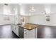 Open floor plan with a kitchen island, stainless steel appliances, and dark hardwood floors at 2542 N Riley Rd, Buckeye, AZ 85396
