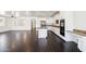Open kitchen with white cabinets, stainless appliances, a center island, and dark hardwood floors at 2542 N Riley Rd, Buckeye, AZ 85396