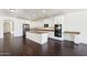 Spacious kitchen featuring white cabinets, an island, stainless appliances, and dark hardwood floors at 2542 N Riley Rd, Buckeye, AZ 85396