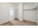 Walk-in closet featuring neutral carpet and built-in shelving and a view to the adjacent room at 2542 N Riley Rd, Buckeye, AZ 85396