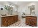 Spacious bathroom boasts dual sinks with stylish wooden cabinets, patterned floor tiles, and serene decor at 4531 E Quartz Mountain Rd, Paradise Valley, AZ 85253