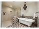 Bathroom showcasing a freestanding tub, modern shower, unique lighting fixture, and decorative tile accents at 4531 E Quartz Mountain Rd, Paradise Valley, AZ 85253