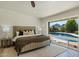 Bright main bedroom with a pool view, neutral decor, stylish patterned flooring, and a comfortable king-sized bed at 4531 E Quartz Mountain Rd, Paradise Valley, AZ 85253