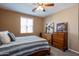 Spacious bedroom with wood furniture and ceiling fan at 4718 E Thunderheart Trl # 103, Gilbert, AZ 85297