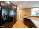 Modern kitchen with dark wood cabinets, granite countertops, and stainless steel appliances at 4718 E Thunderheart Trl # 103, Gilbert, AZ 85297