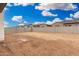 Dirt backyard with block wall separating property lines with clear, sunny skies at 4918 W Beryl Ave, Glendale, AZ 85302