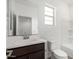 Well-lit bathroom with a dark wood vanity, neutral countertop, shower, and toilet at 4918 W Beryl Ave, Glendale, AZ 85302