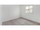 Minimalist bedroom with neutral carpet, white walls, and a window allowing natural light at 4918 W Beryl Ave, Glendale, AZ 85302
