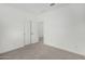 Spare bedroom with neutral carpet, white walls, a closet, and a view through double doors at 4918 W Beryl Ave, Glendale, AZ 85302