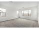 Sunlit bedroom features neutral carpet, white walls, and windows with views of the neighborhood at 4918 W Beryl Ave, Glendale, AZ 85302