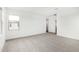 Well-lit bedroom with neutral carpet, white walls, and a door leading to an adjacent room at 4918 W Beryl Ave, Glendale, AZ 85302