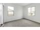 Bright, carpeted bedroom with two windows offering natural light and neighborhood views at 4918 W Beryl Ave, Glendale, AZ 85302