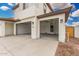 Large three-car garage with automatic doors, electrical panels, and a level concrete floor at 4918 W Beryl Ave, Glendale, AZ 85302