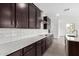 Contemporary kitchen featuring quartz countertops, stainless hood, and dark wood cabinets at 4918 W Beryl Ave, Glendale, AZ 85302