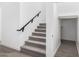 Carpeted staircase with modern black handrail, with tile floors and a closet at the bottom at 4918 W Beryl Ave, Glendale, AZ 85302