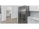 Stainless steel refrigerator in a kitchen with white cabinets and wood-look floors at 6903 W Irwin Ave, Laveen, AZ 85339