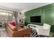 Living room with green feature wall, sectional sofa and wood floors at 7970 E Camelback Rd # 101, Scottsdale, AZ 85251
