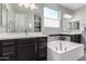 Elegant bathroom with double vanity, soaking tub, and modern lighting at 18865 W Mescal St, Surprise, AZ 85388